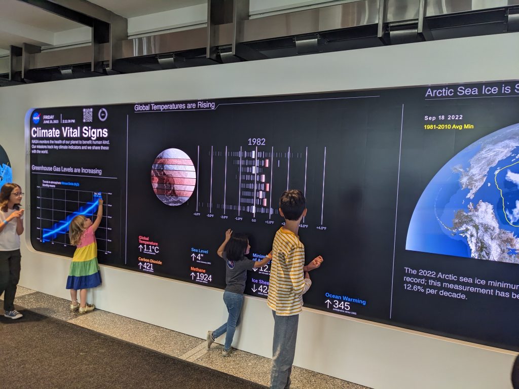 Children tracing the data visualizations on the EIC hyperwall.